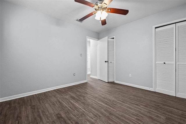 unfurnished bedroom featuring two closets, visible vents, dark wood-type flooring, ceiling fan, and baseboards