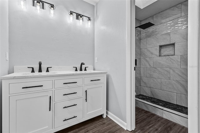 full bathroom with a stall shower, a sink, and wood finished floors