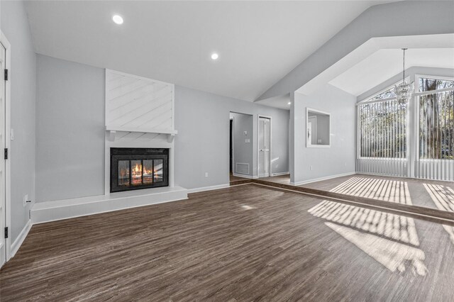 unfurnished living room featuring a fireplace, baseboards, vaulted ceiling, and wood finished floors