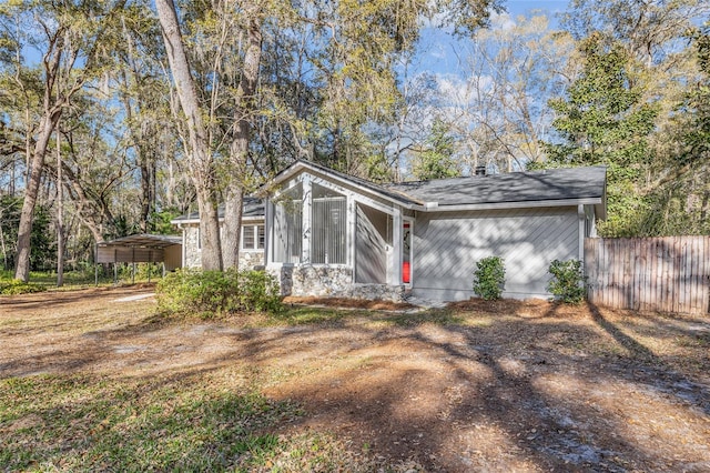 view of front of house with a carport and fence