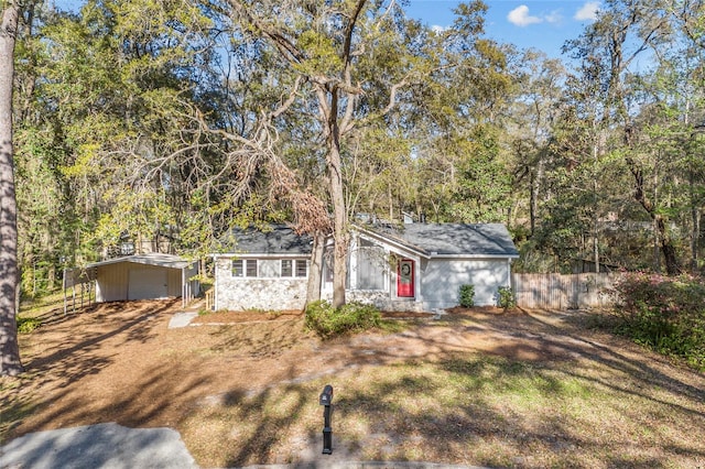 ranch-style house featuring stone siding and fence