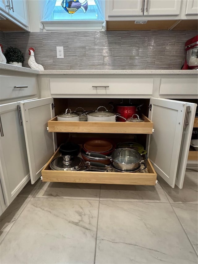 room details with light countertops, white cabinetry, and decorative backsplash