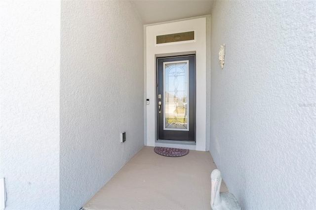 view of exterior entry featuring stucco siding