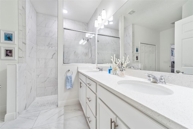 full bath featuring double vanity, marble finish floor, walk in shower, and a sink