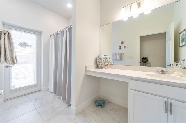 bathroom featuring marble finish floor, baseboards, curtained shower, and vanity