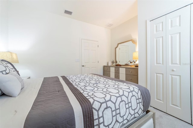 bedroom with light carpet, a closet, and visible vents