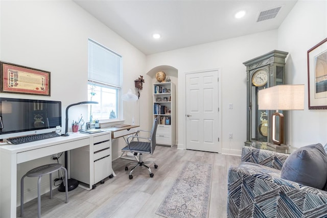 office area with light wood-type flooring, visible vents, arched walkways, and recessed lighting