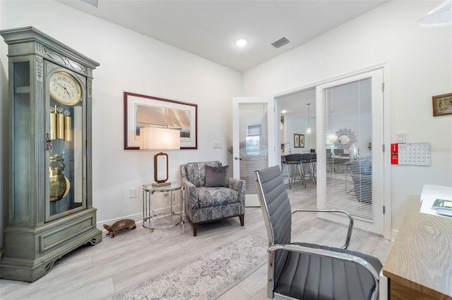 sitting room featuring light wood-style floors, baseboards, and visible vents