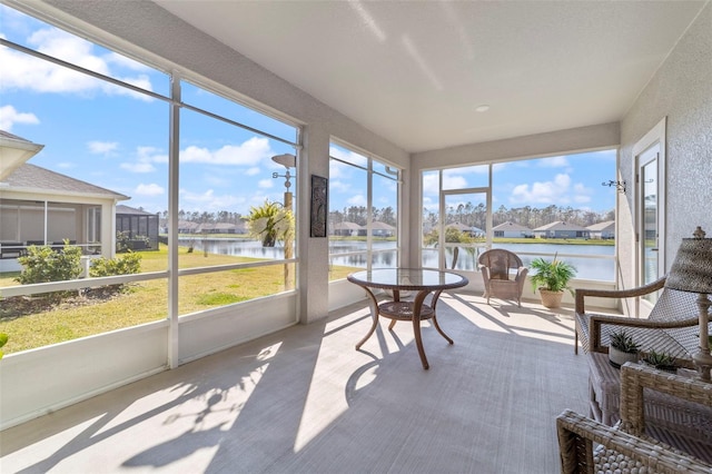 sunroom featuring a water view