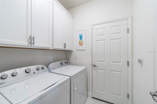 clothes washing area featuring cabinet space and washer and clothes dryer