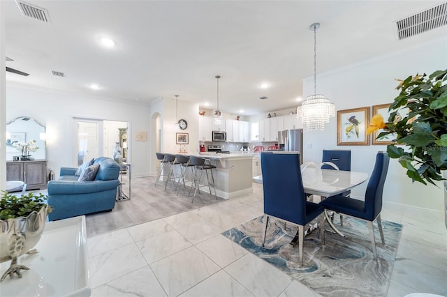 dining room featuring arched walkways, recessed lighting, visible vents, and crown molding