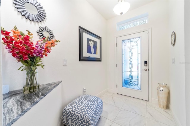 foyer entrance with marble finish floor and baseboards