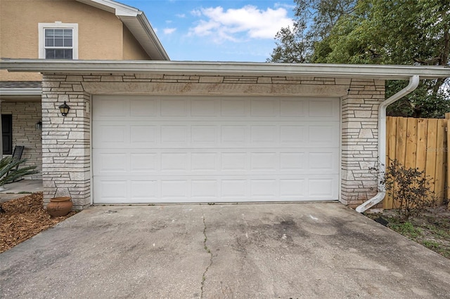 garage with driveway and fence