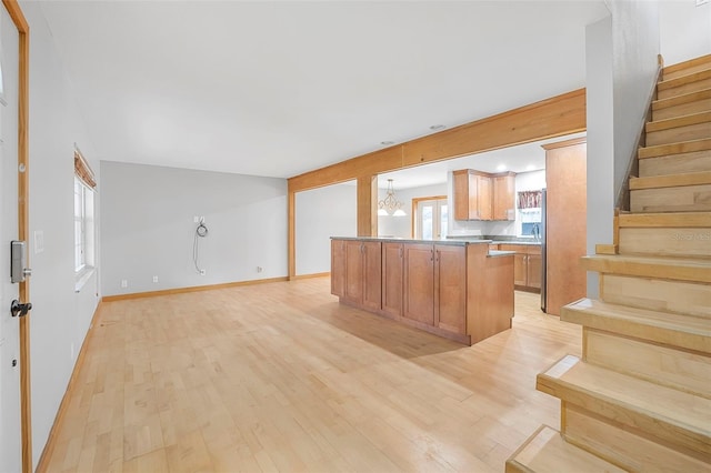 kitchen featuring light wood finished floors, pendant lighting, and open floor plan