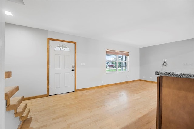 foyer featuring light wood finished floors and baseboards