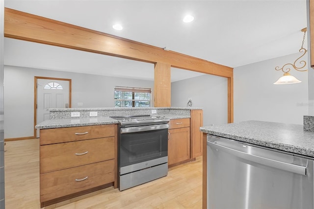 kitchen with brown cabinetry, light wood-style flooring, light stone counters, decorative light fixtures, and stainless steel appliances