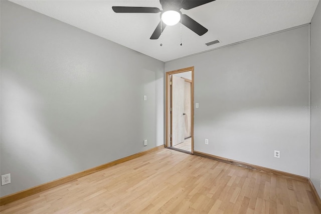 unfurnished room with light wood finished floors, visible vents, and baseboards