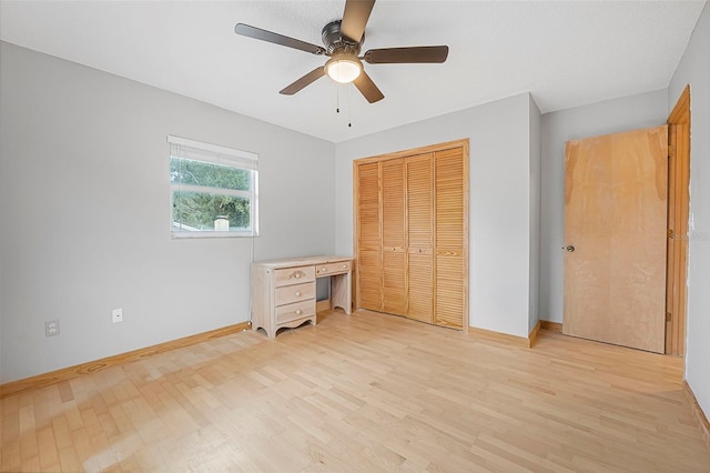 unfurnished bedroom featuring a closet, baseboards, ceiling fan, and light wood finished floors