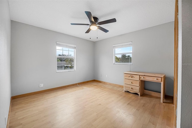 empty room featuring a healthy amount of sunlight, light wood-style flooring, and baseboards