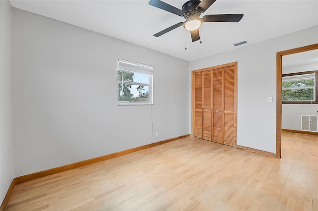 unfurnished bedroom featuring light wood-style floors, a closet, visible vents, and baseboards