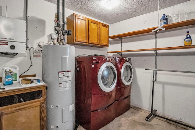 clothes washing area featuring washing machine and dryer, water heater, cabinet space, and a textured ceiling