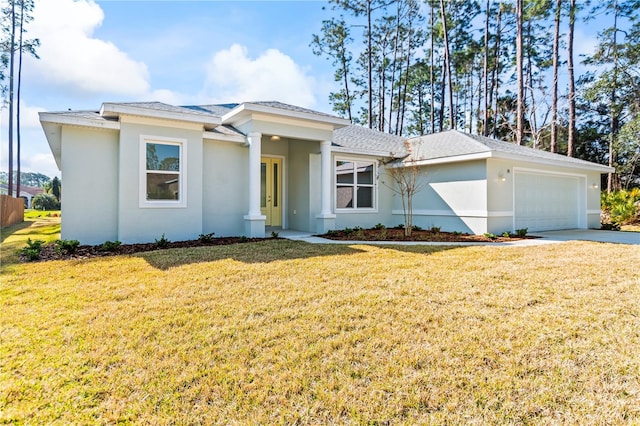 view of front of home with driveway, a front lawn, an attached garage, and stucco siding