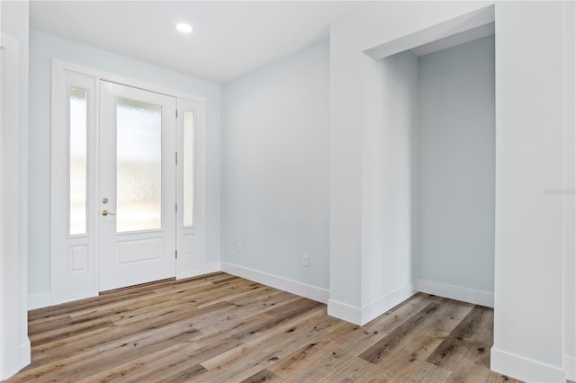 foyer entrance featuring baseboards, a wealth of natural light, and wood finished floors