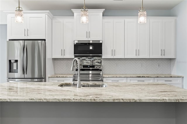 kitchen featuring backsplash, appliances with stainless steel finishes, white cabinets, and a sink