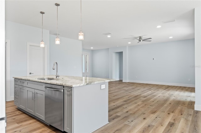 kitchen featuring light stone counters, gray cabinets, light wood-style flooring, stainless steel dishwasher, and a sink