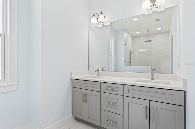 bathroom with a stall shower, marble finish floor, visible vents, and a sink