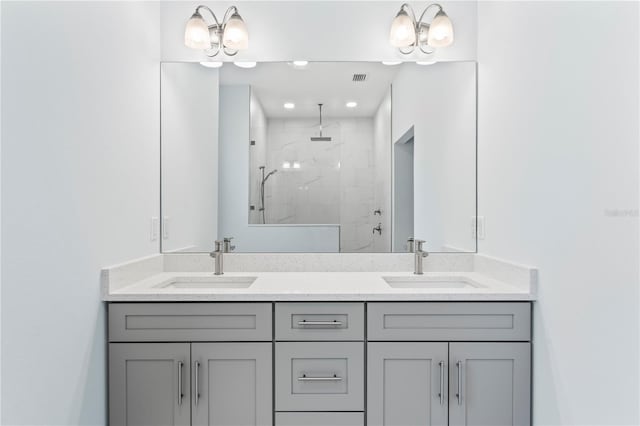 full bath featuring visible vents, a sink, a shower stall, and double vanity