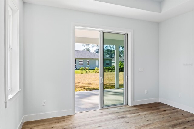 doorway to outside featuring baseboards and wood finished floors