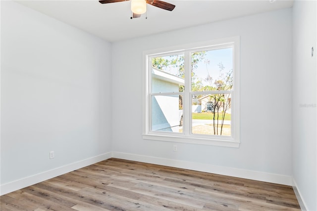 empty room featuring a healthy amount of sunlight, light wood finished floors, and baseboards