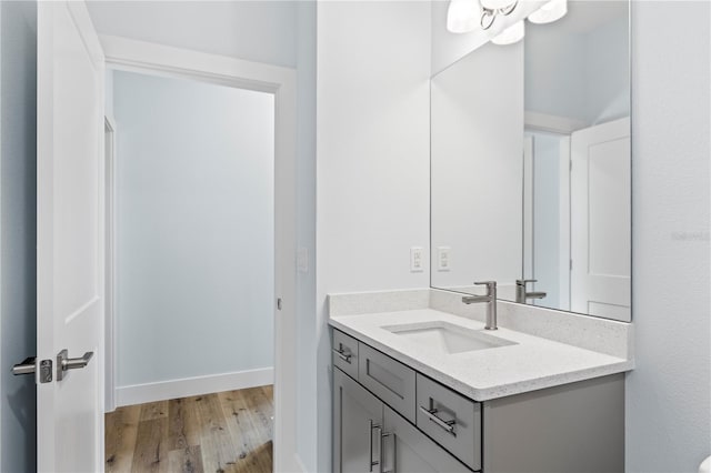 bathroom with vanity, baseboards, and wood finished floors