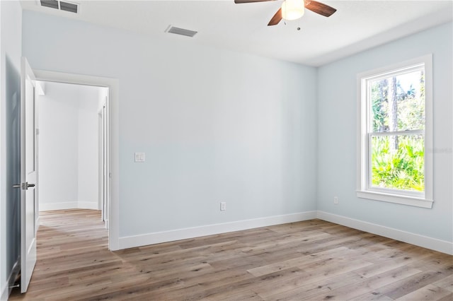 unfurnished room with baseboards, visible vents, and light wood finished floors