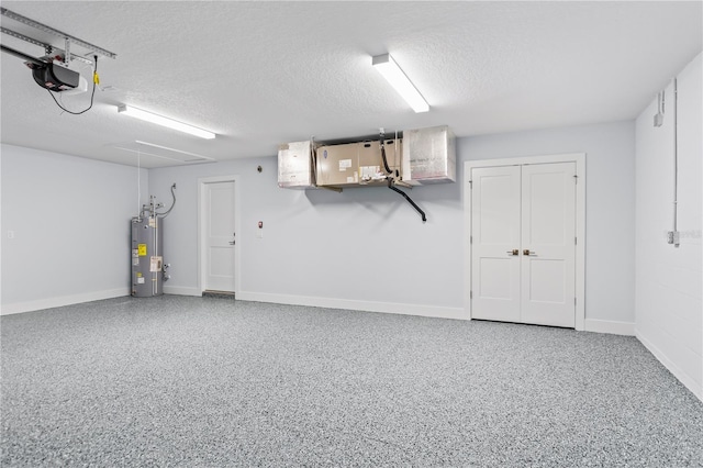 garage featuring baseboards, electric water heater, and a garage door opener