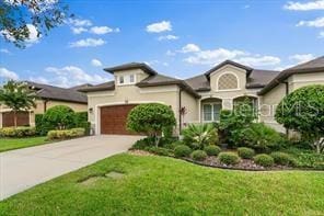 view of front of home with concrete driveway, a front lawn, and an attached garage