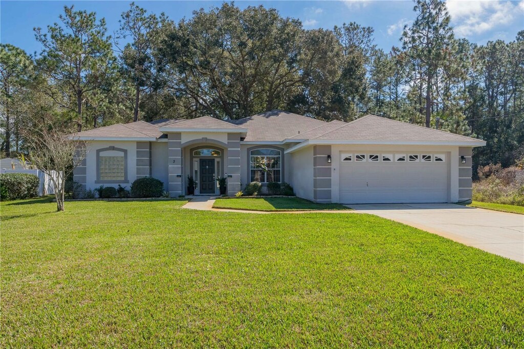3 Walnut Pl, Palm Coast, FL 32164 - single story home featuring a garage, driveway, a front yard, and stucco siding