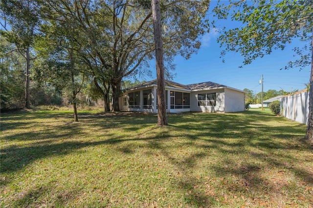 view of yard with a sunroom and fence