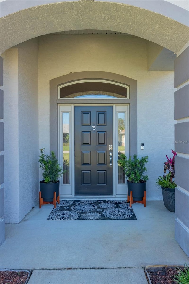 doorway to property featuring stucco siding