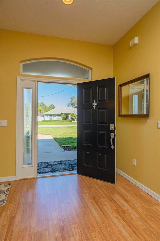 entryway with light wood-type flooring and baseboards