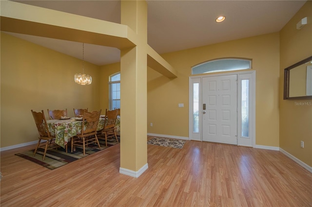 entrance foyer featuring light wood-style floors, baseboards, and a chandelier