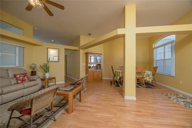 living area with light wood-style floors, plenty of natural light, and baseboards