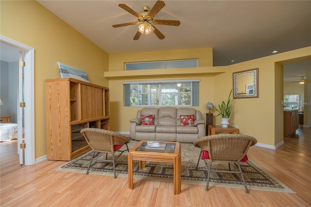 living room with a ceiling fan, baseboards, plenty of natural light, and light wood finished floors