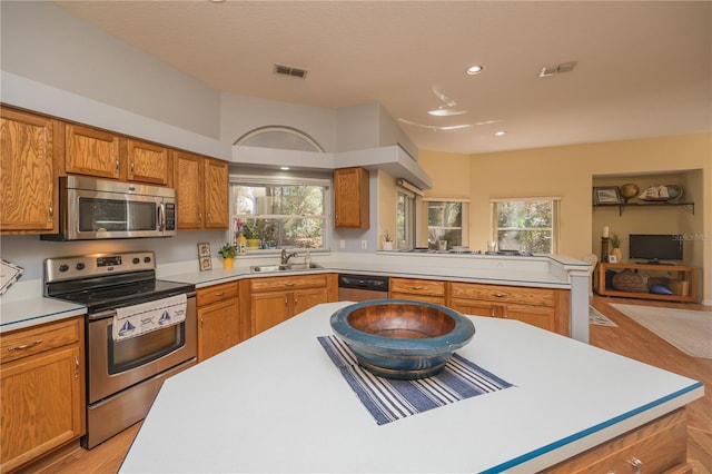 kitchen with a sink, visible vents, stainless steel appliances, and light countertops