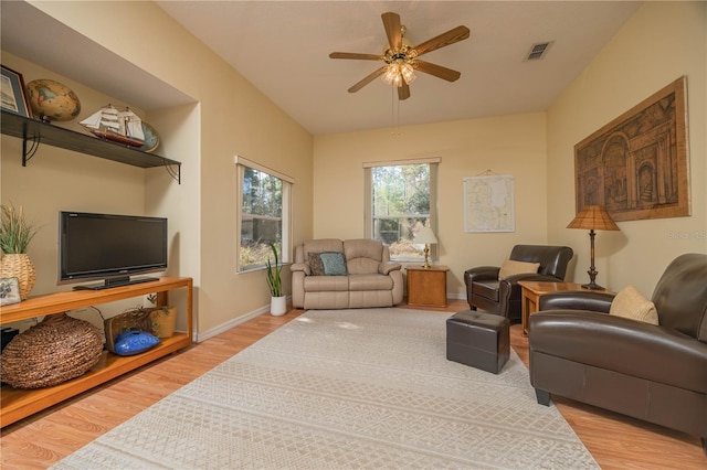 living area featuring light wood-style flooring, visible vents, baseboards, and ceiling fan