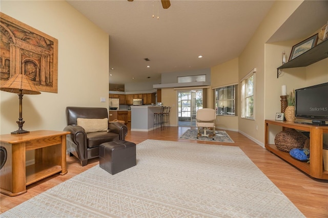 living room with recessed lighting, ceiling fan, light wood-style flooring, and baseboards