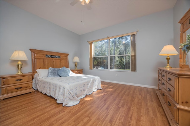 bedroom with light wood-type flooring, ceiling fan, lofted ceiling, and baseboards