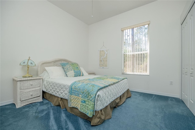 carpeted bedroom with lofted ceiling, a closet, and baseboards