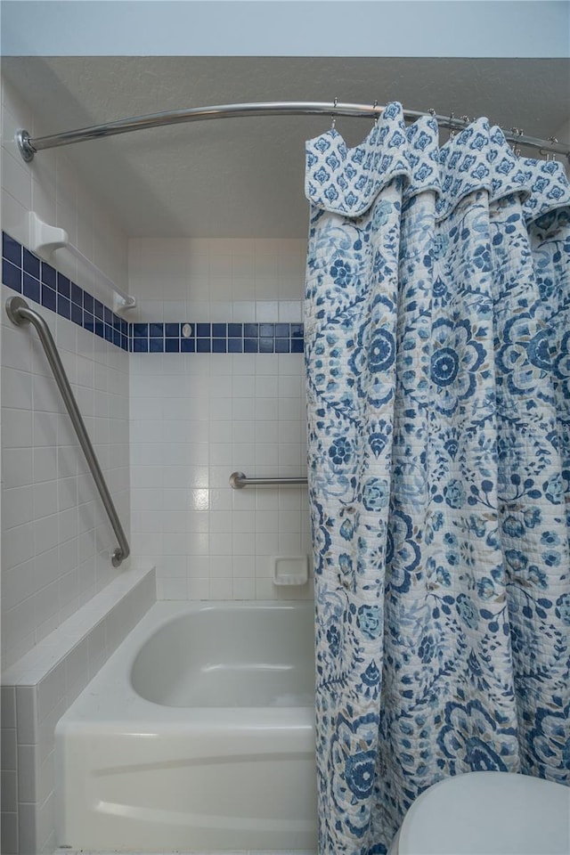 full bathroom with a shower with shower curtain and toilet